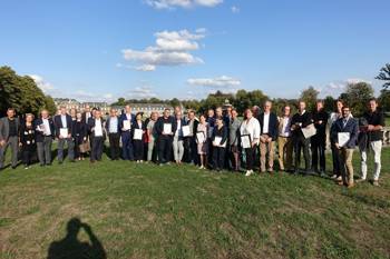 Crowds of people stand holding praise in their hands for a commemorative photo in a park